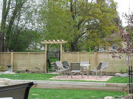 Black ornamental iron fence following a sloped terraced lakeside yard near Peterborough, installed by Durable Fence