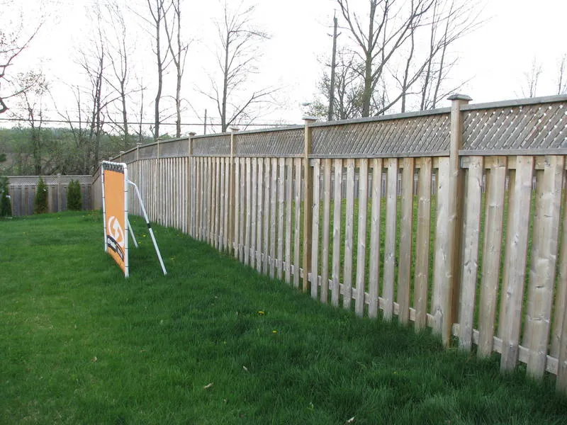 Lattice-capped picket fence run installed along a lawn in the Kawarthas by Durable Fence