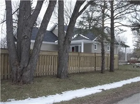 Wood picket fence protecting a front yard through winter conditions, repaired by Durable Fence in the Kawarthas