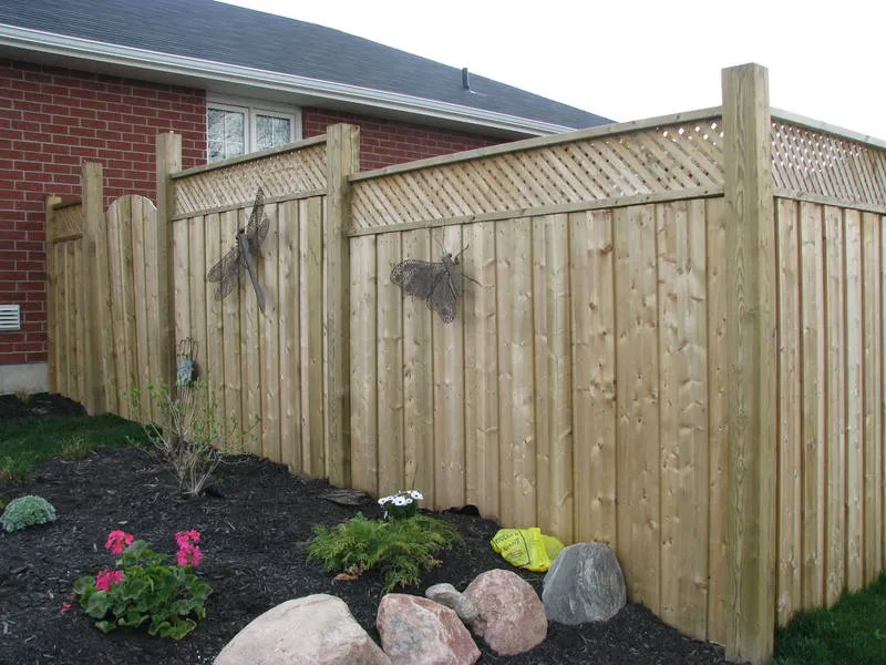Pressure-treated wood privacy fence with lattice top and arched gate built by Durable Fence in Peterborough